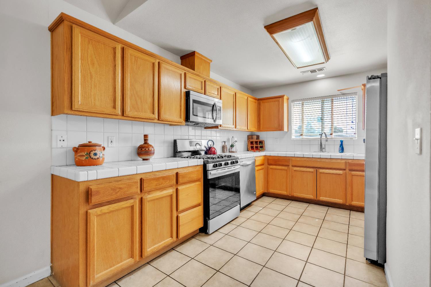 4688 Pacific Avenue Olivehurst, CA 95961 - Photo 76 of 91 a kitchen with stainless steel appliances granite countertop a sink counter space cabinets and a large window