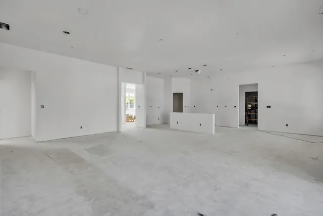 a view of an empty room with a window and a ceiling fan