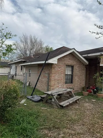 a backyard of a house with table and chairs
