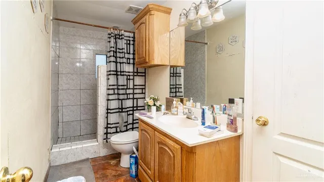 a bathroom with a sink a toilet and shower