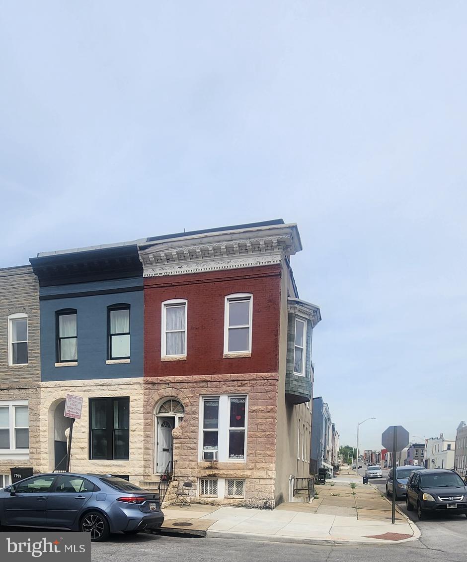 1746 East Oliver Street Baltimore, MD 21213 - Photo 2 of 17 a front view of a building with lot of cars and trees