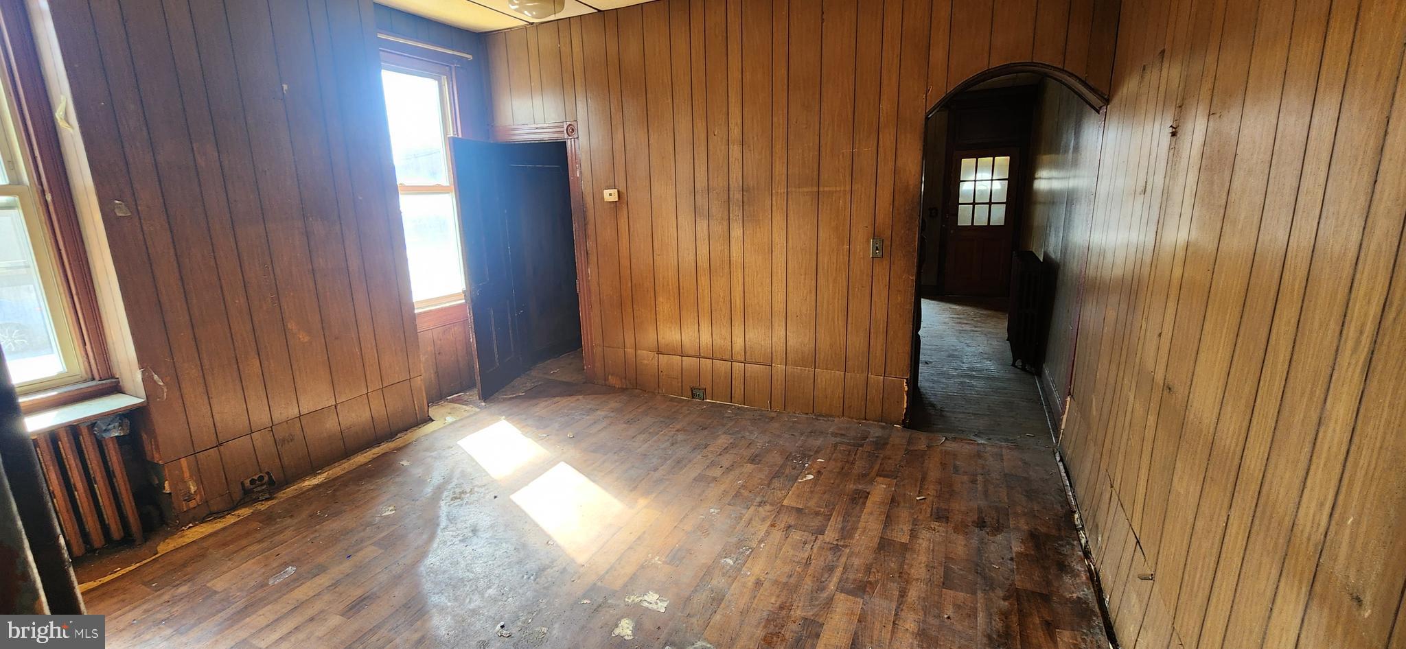 1746 East Oliver Street Baltimore, MD 21213 - Photo 6 of 17 an empty room with wooden floor and windows