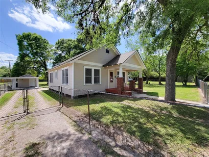 a view of a house with backyard and a tree