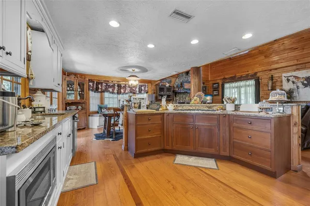 a kitchen with stainless steel appliances granite countertop a refrigerator and a stove top oven