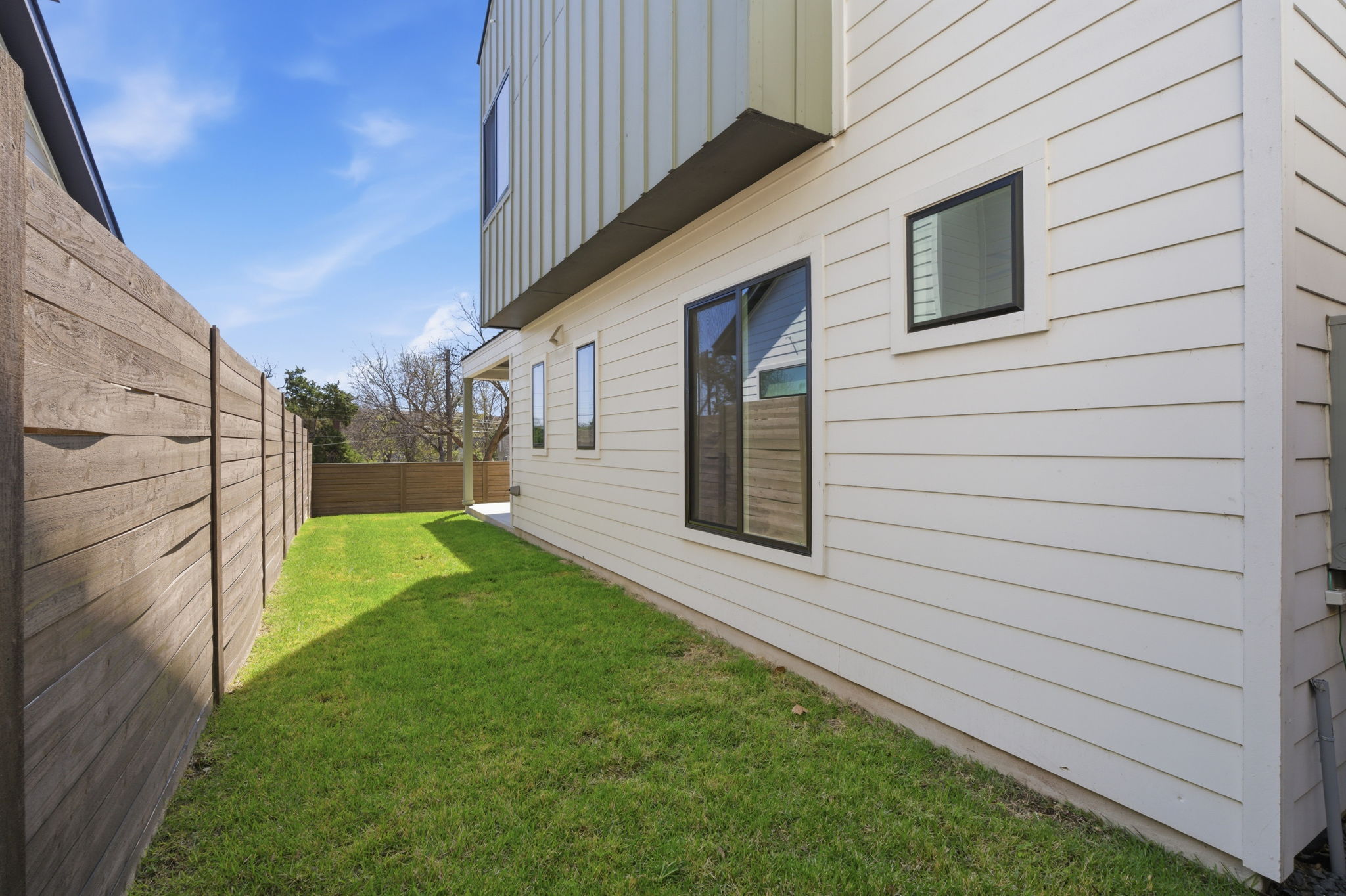 400 Post Rd Drive Austin, TX 78704 - Photo 23 of 23 View of side of home with a fenced backyard and board and batten siding