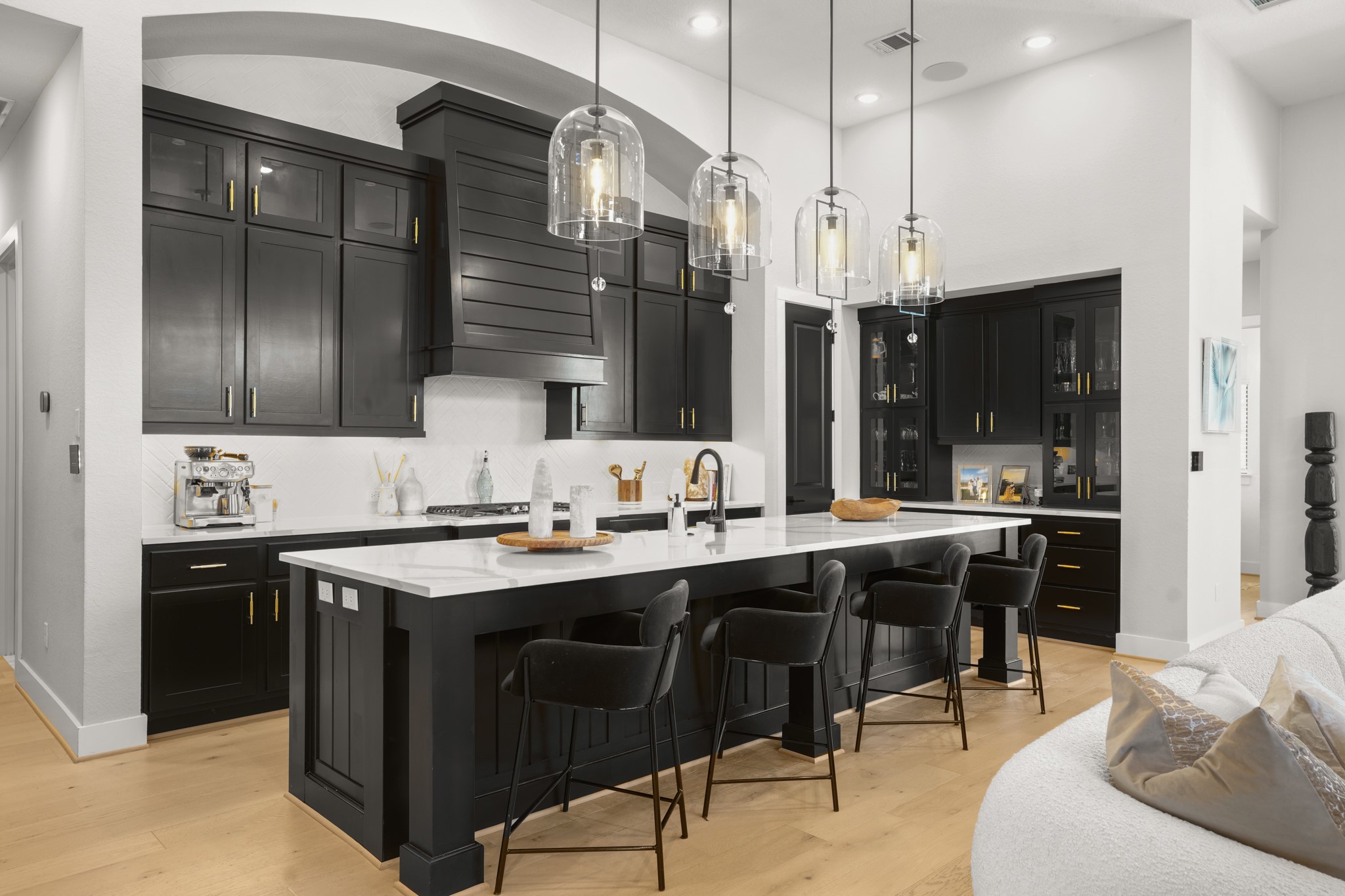 154 LITTLE Strm Cove Austin, TX 78737 - Photo 1 of 37 Dramatic black custom cabinetry contrasts beautifully with a massive quartz-topped island and light wood flooring with custom light fixtures. Dry bar with perfection.
