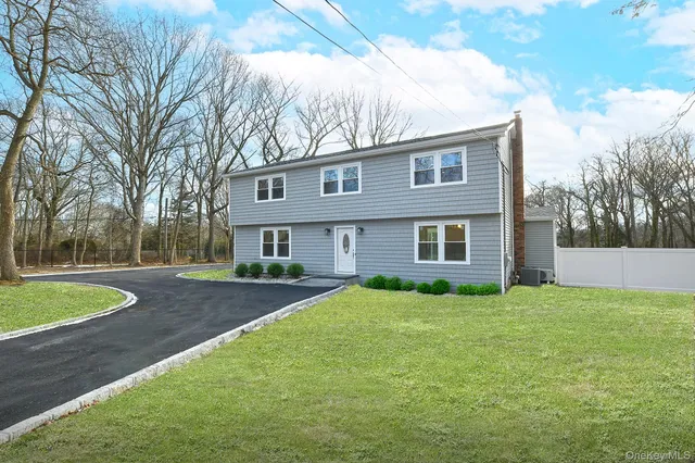 a view of a yard in front of a house with large trees