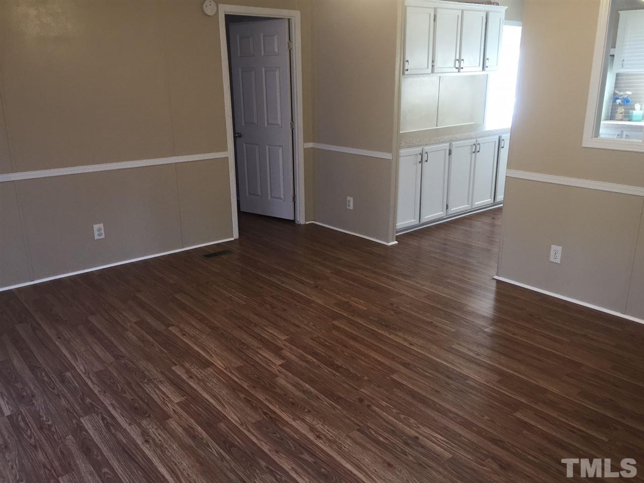 1313 Yakimas Road Raleigh, NC 27603 - Photo 2 of 9 an empty room with wooden floor and windows