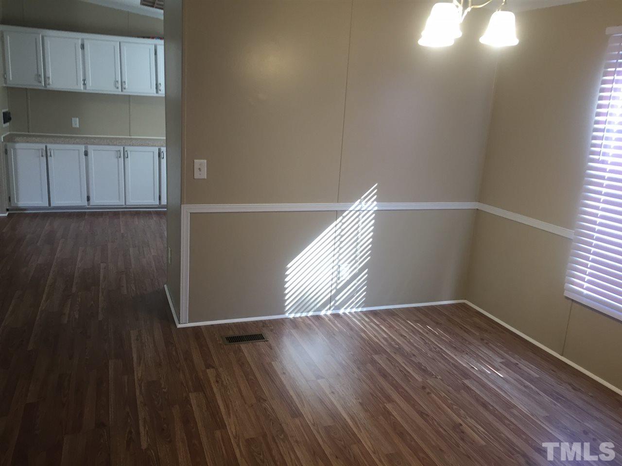 1313 Yakimas Road Raleigh, NC 27603 - Photo 5 of 9 a view of an empty room with wooden floor and a window