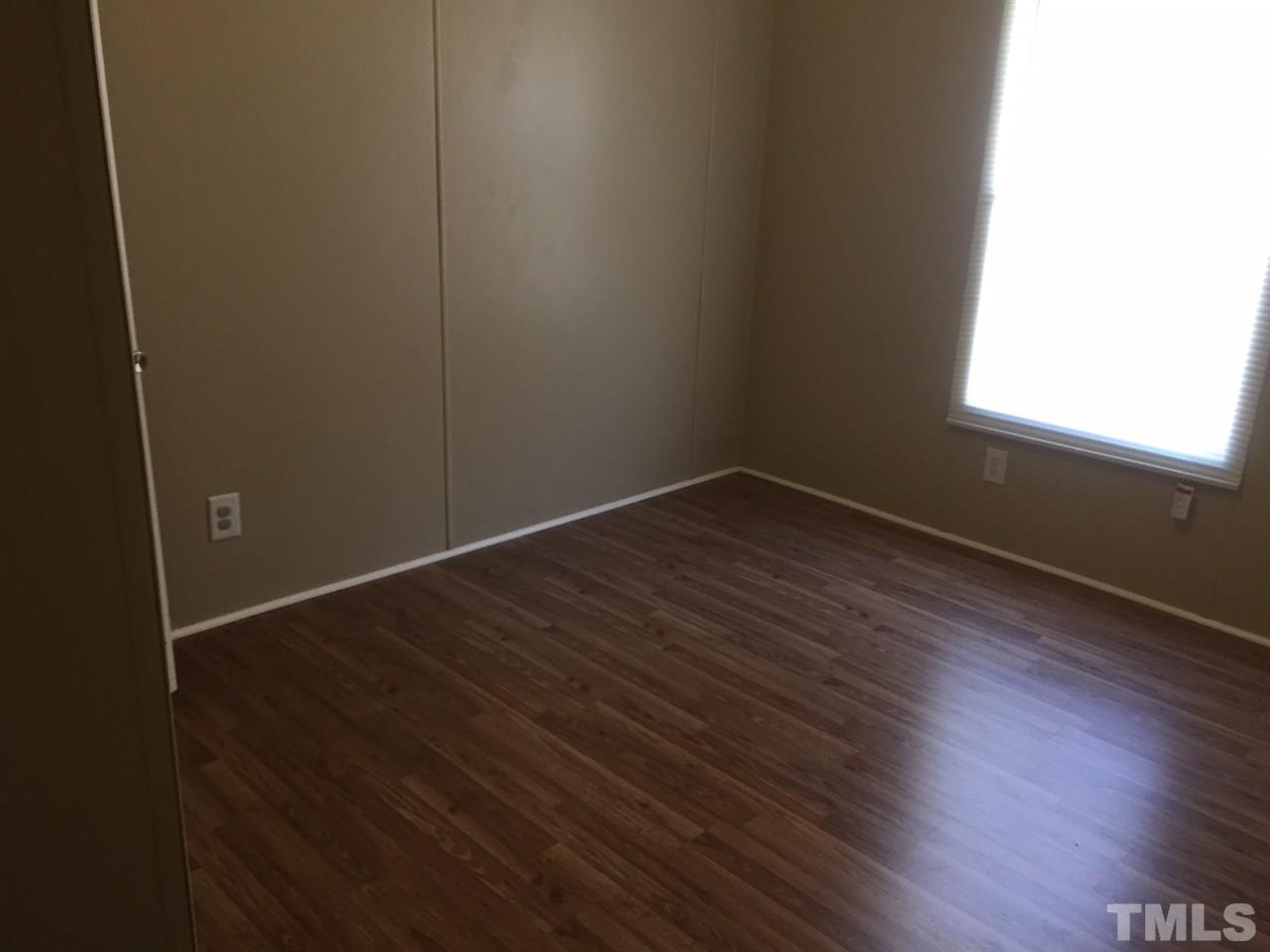1313 Yakimas Road Raleigh, NC 27603 - Photo 6 of 9 an empty room with wooden floor and windows