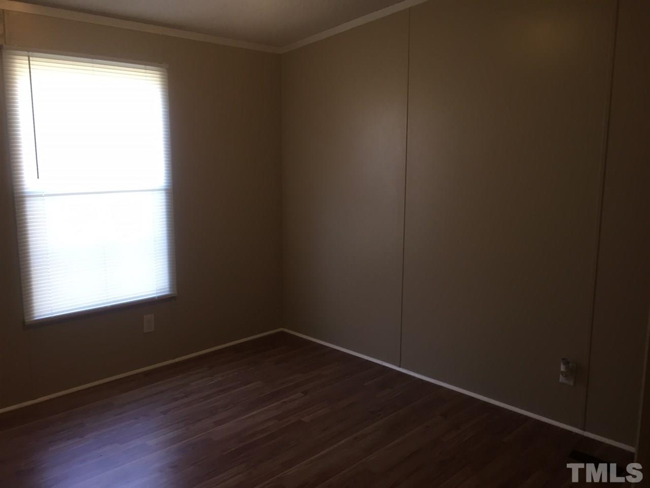 1313 Yakimas Road Raleigh, NC 27603 - Photo 7 of 9 a view of an empty room with wooden floor and a window