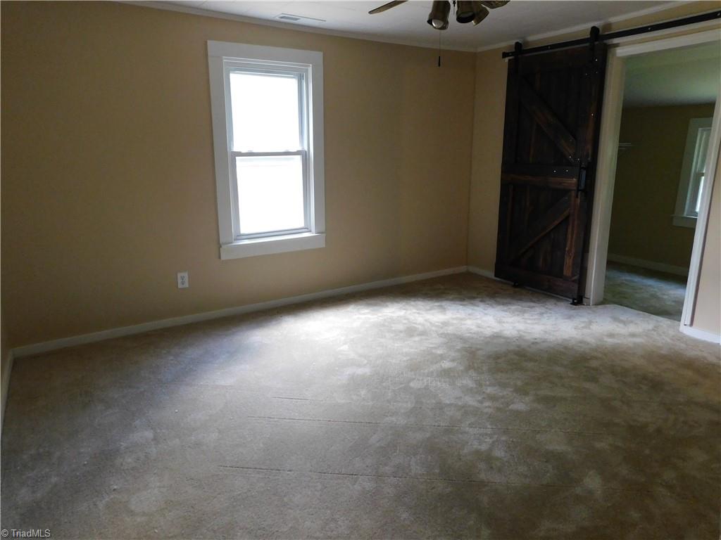 1135 Doc Hundley Road Westfield, NC 27053 - Photo 17 of 30 Primary bedroom w/ barn door to walk-in closet