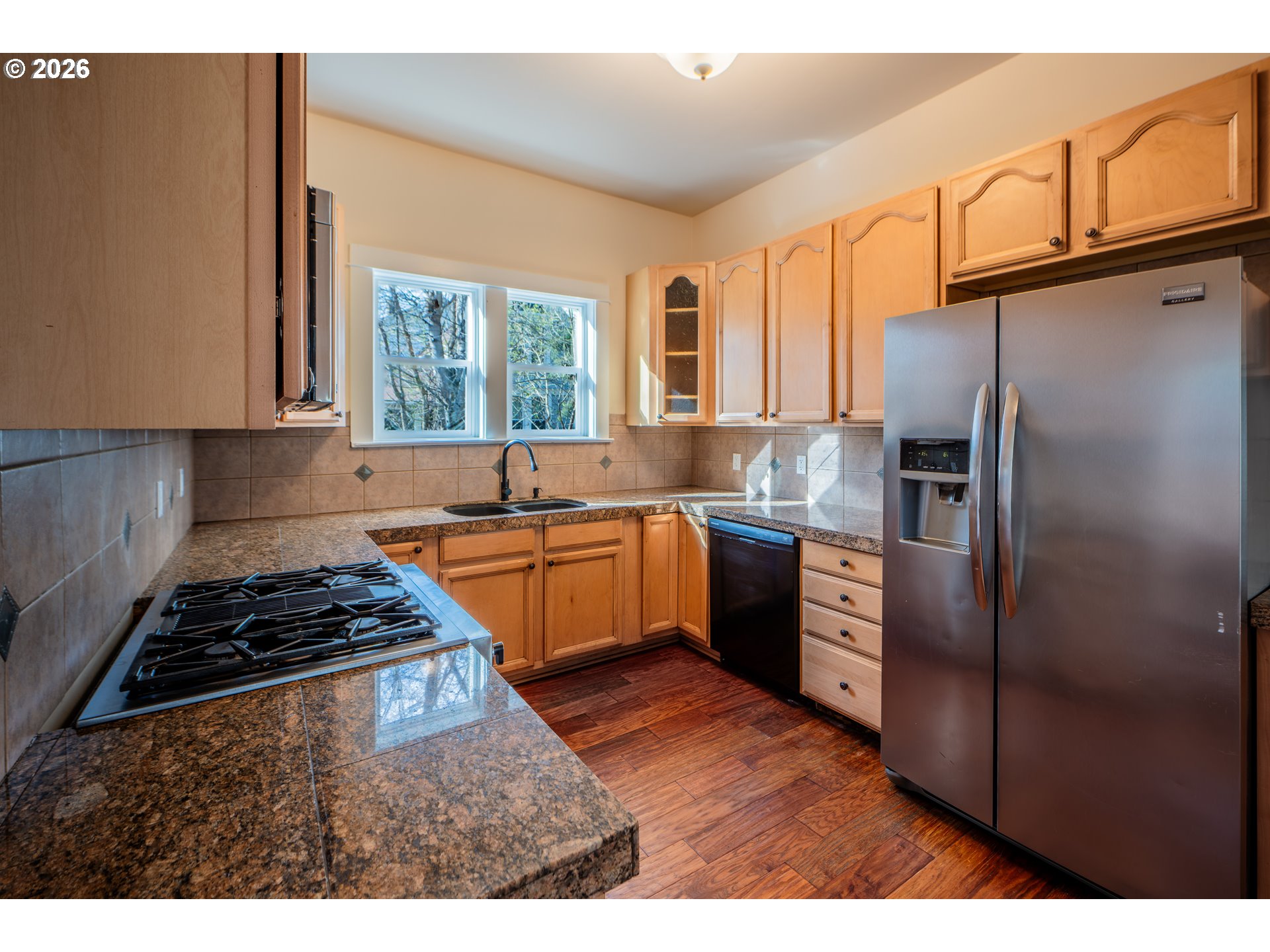 110 West 8th Street The Dalles, OR 97058 - Photo 12 of 43 a kitchen with stainless steel appliances granite countertop a refrigerator a sink a stove and white cabinets