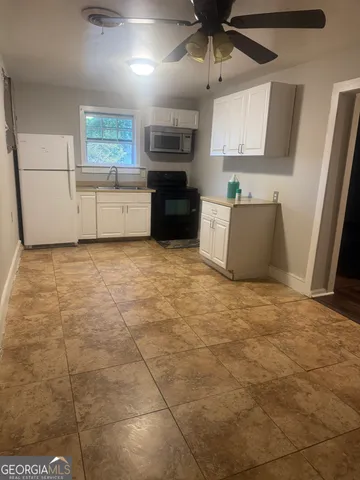 a large kitchen with cabinets and a wooden floor