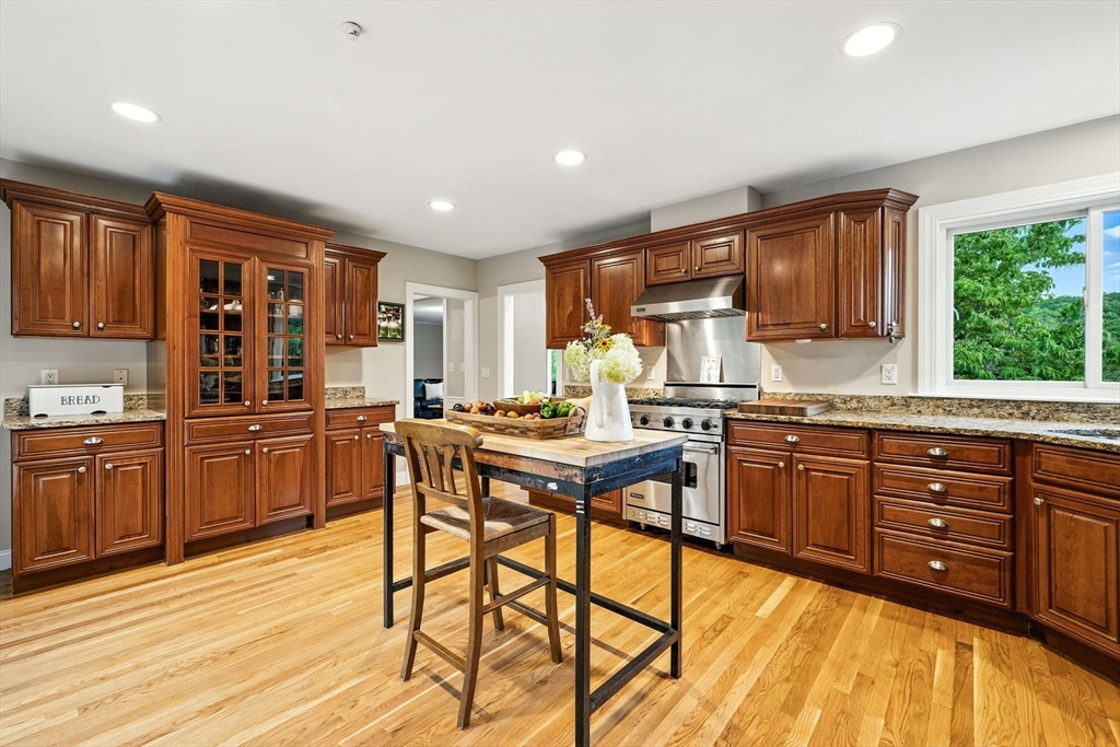 52 Wenham Road Topsfield, MA 01983 - Photo 11 of 42 a kitchen with stainless steel appliances granite countertop wooden cabinets a refrigerator a sink a stove and wooden cabinets