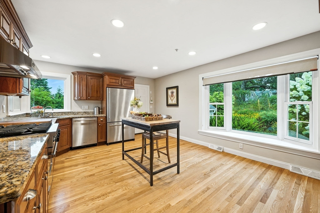 52 Wenham Road Topsfield, MA 01983 - Photo 13 of 42 a kitchen with stainless steel appliances granite countertop a stove a sink dishwasher a refrigerator and white cabinets with wooden floor