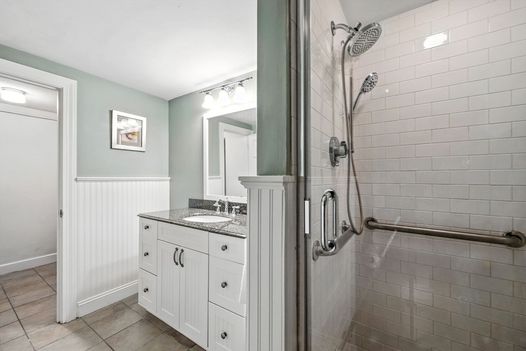 52 Wenham Road Topsfield, MA 01983 - Photo 32 of 42 a bathroom with a double vanity sink a mirror and a shower
