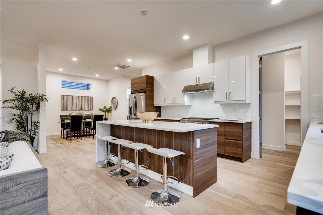 5603 42nd Avenue Southwest Seattle, WA 98136 - Photo 16 of 40 a kitchen with stainless steel appliances granite countertop a center island and a wooden cabinets