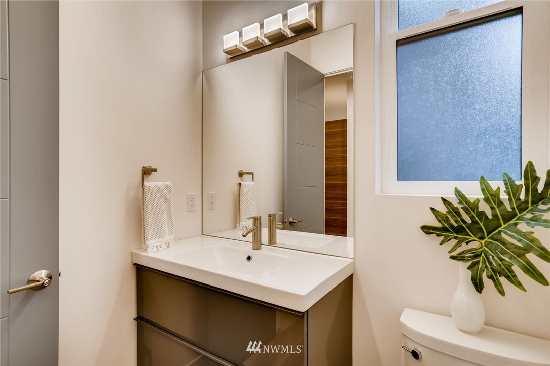 5603 42nd Avenue Southwest Seattle, WA 98136 - Photo 18 of 40 a bathroom with a sink a mirror and a potted plant
