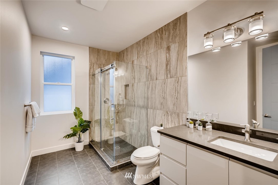 5603 42nd Avenue Southwest Seattle, WA 98136 - Photo 30 of 40 a bathroom with a double vanity sink toilet and shower