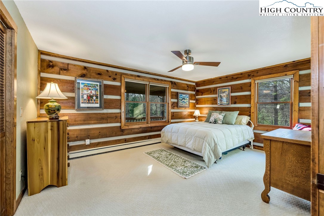 214 Deer Ridge Road Crumpler, NC 28617 - Photo 18 of 44 a bedroom with a large bed and a chandelier