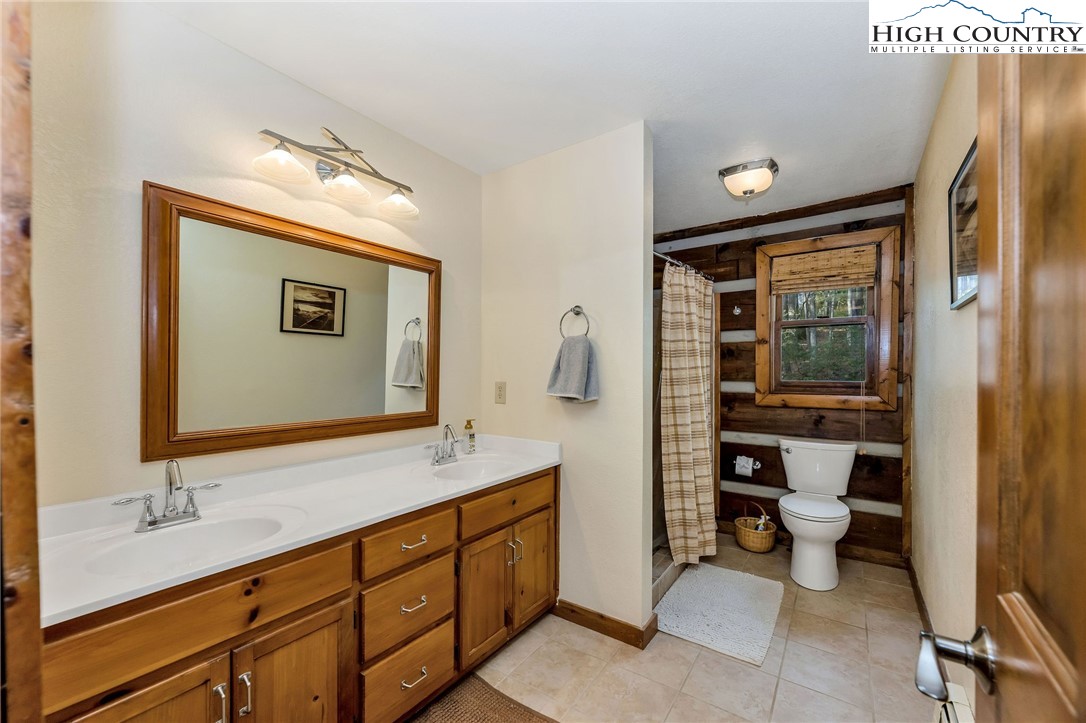 214 Deer Ridge Road Crumpler, NC 28617 - Photo 21 of 44 a bathroom with a double vanity sink toilet and shower