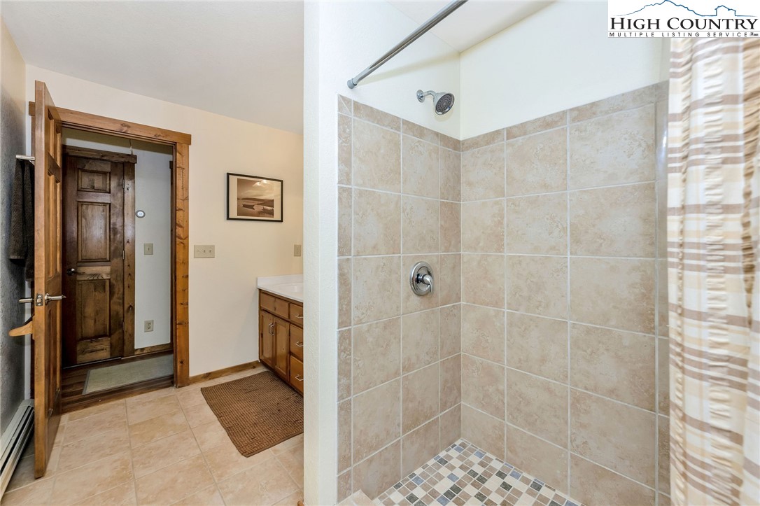 214 Deer Ridge Road Crumpler, NC 28617 - Photo 22 of 44 a bathroom with a shower and a sink