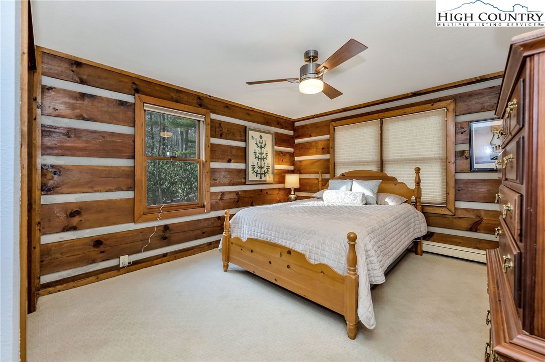 214 Deer Ridge Road Crumpler, NC 28617 - Photo 23 of 44 a bedroom with a large bed and a chandelier