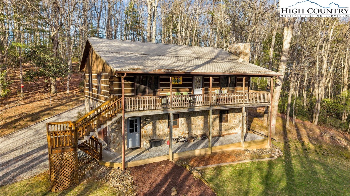 214 Deer Ridge Road Crumpler, NC 28617 - Photo 3 of 44 a view of a patio with table and chairs with wooden floor and fence