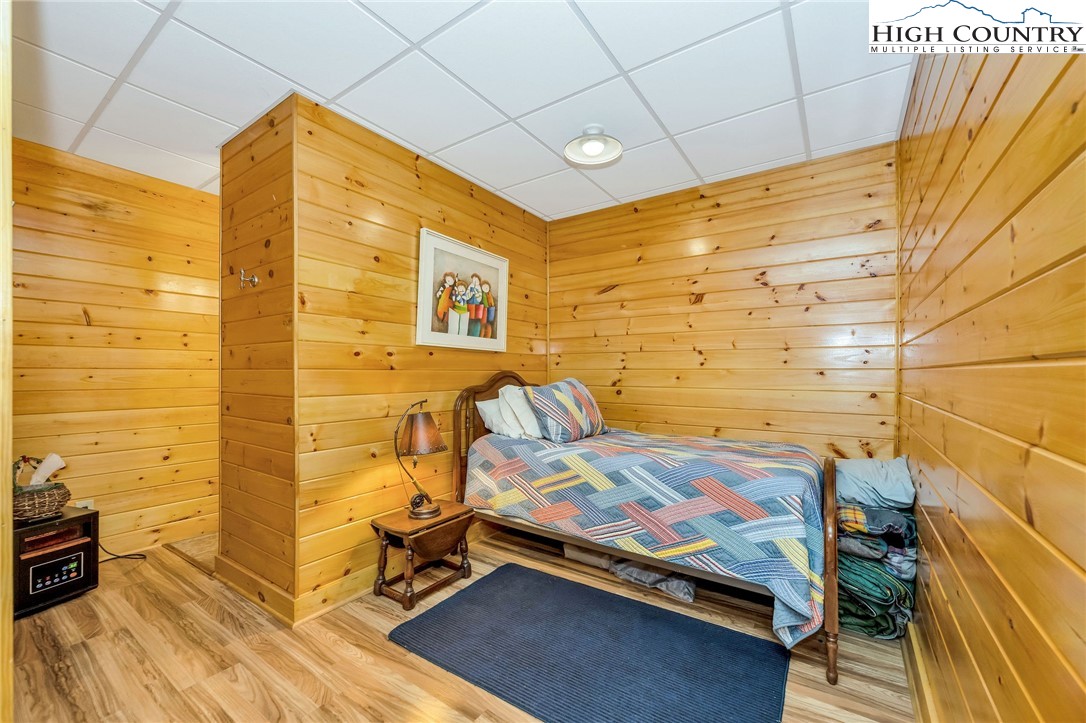 214 Deer Ridge Road Crumpler, NC 28617 - Photo 31 of 44 a bedroom with a bed and wooden floor