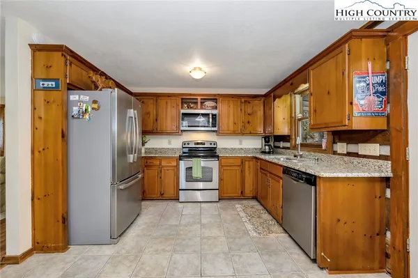 a kitchen with granite countertop a refrigerator and a sink