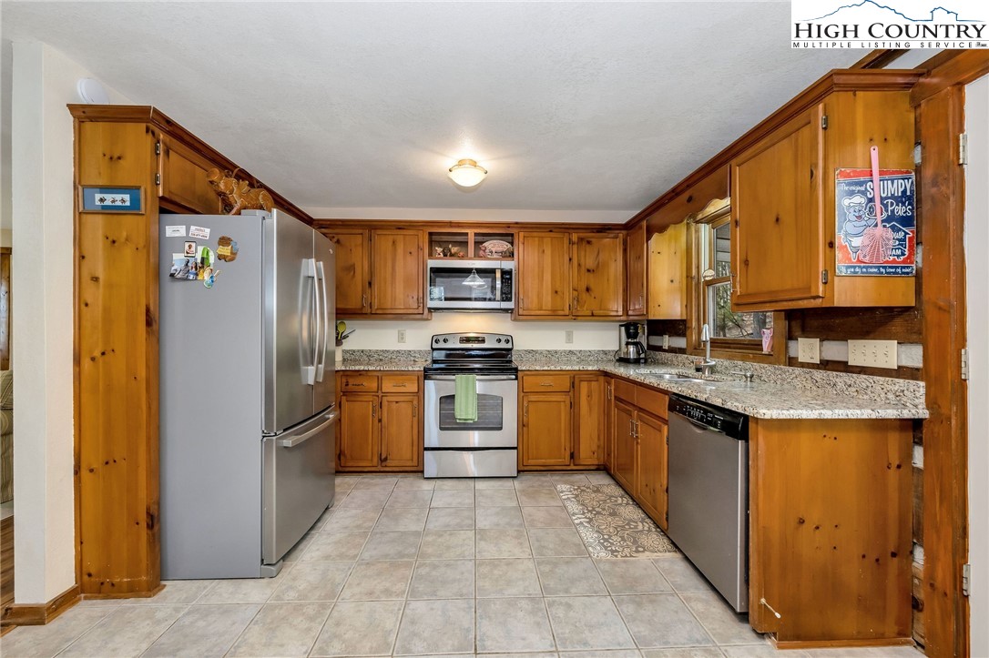 214 Deer Ridge Road Crumpler, NC 28617 - Photo 7 of 44 a kitchen with granite countertop a refrigerator and a sink