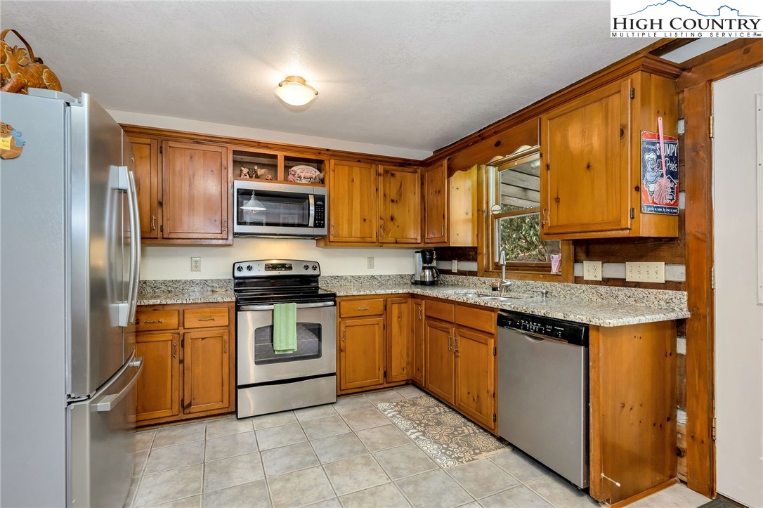 214 Deer Ridge Road Crumpler, NC 28617 - Photo 9 of 44 a kitchen with stainless steel appliances granite countertop a stove top oven a sink and a refrigerator