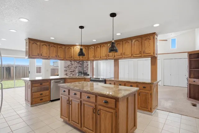 a kitchen with stainless steel appliances granite countertop a sink and a refrigerator