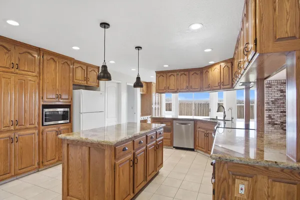 a kitchen with stainless steel appliances granite countertop a stove a sink and a refrigerator