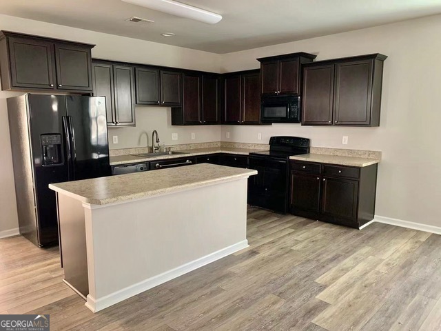177 Dunleith Parkway Southwest Marietta, GA 30008 - Photo 2 of 17 a kitchen with wooden cabinets and refrigerator