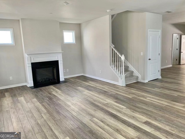 177 Dunleith Parkway Southwest Marietta, GA 30008 - Photo 4 of 17 a view of an empty room with wooden floor fireplace and a window