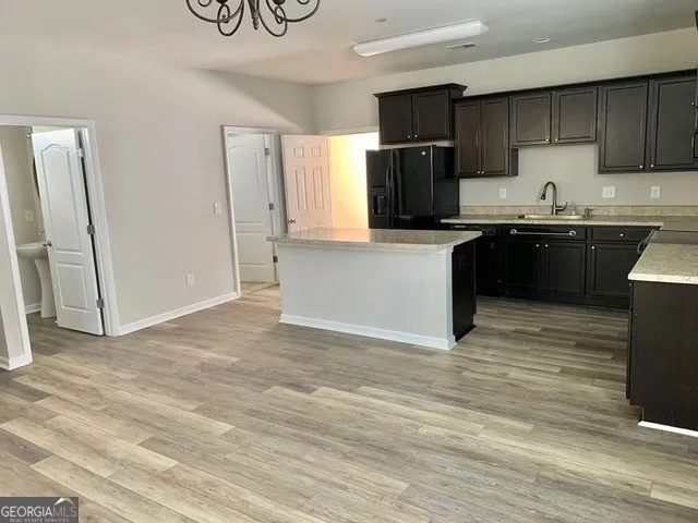 a kitchen with granite countertop a refrigerator and a sink