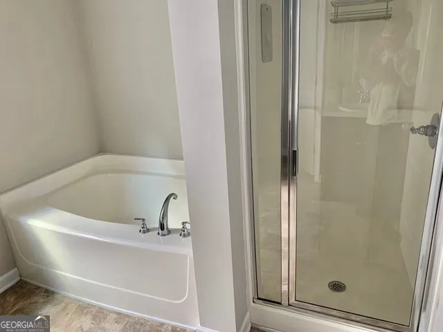 a white bath tub sitting next to a shower