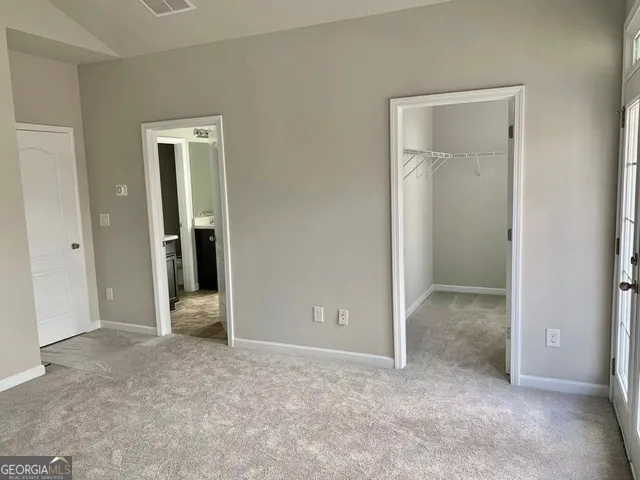 an empty room with closet and a bathroom