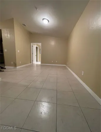 a view of an empty room with kitchen and a sink
