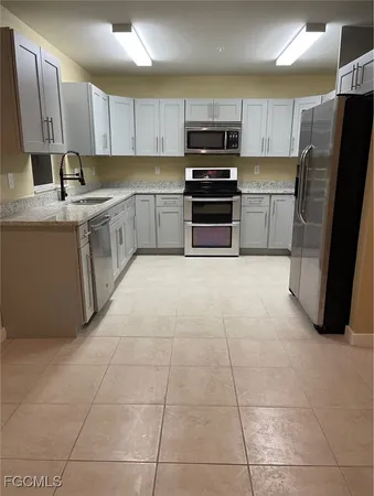 a kitchen with stainless steel appliances a refrigerator sink and microwave