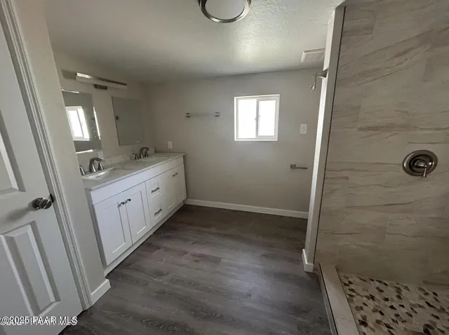 a bathroom with a granite countertop sink a toilet and shower