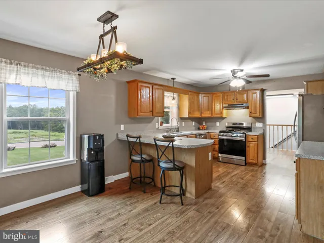 a kitchen with stainless steel appliances granite countertop a sink stove and refrigerator