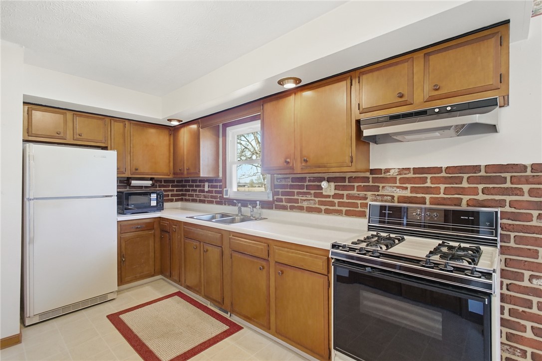 6718 Old Columbus Road South Vienna, OH 45369 - Photo 10 of 33 This functional kitchen features ample cabinetry and a classic brick-style backsplash.