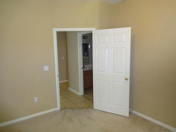 a view of an empty room with closet and wooden floor