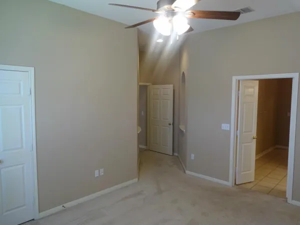 an empty room with closet and a chandelier fan