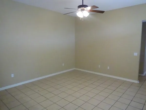 an empty room with a chandelier fan