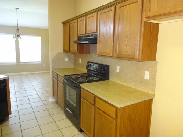 a kitchen with a sink a stove top oven and cabinetry