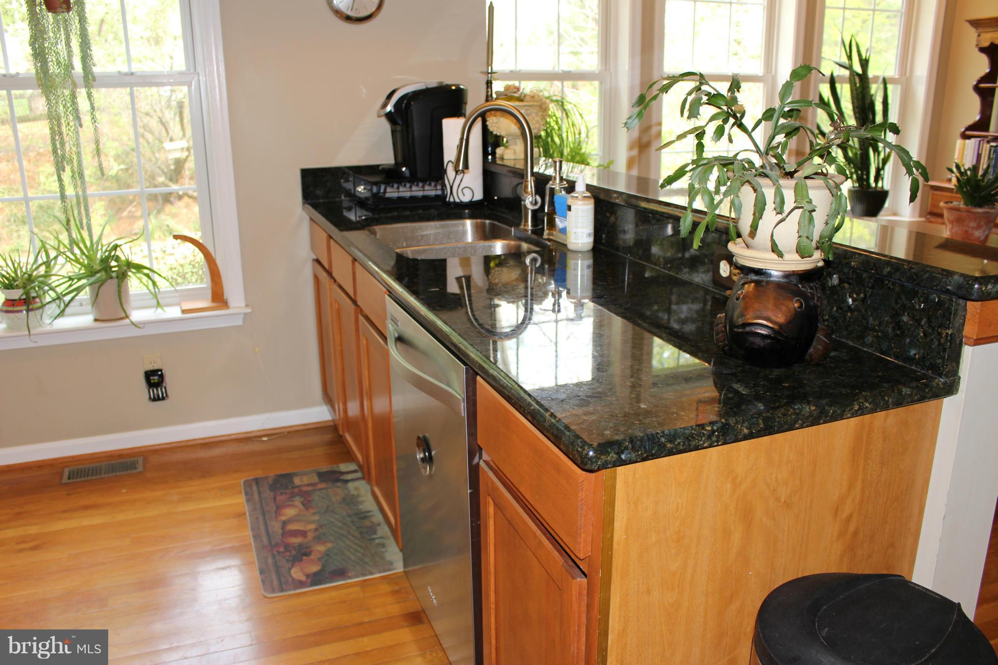 245 Milldale Road Front Royal, VA 22630 - Photo 4 of 29 a kitchen with stainless steel appliances granite countertop a sink a stove and a wooden floor